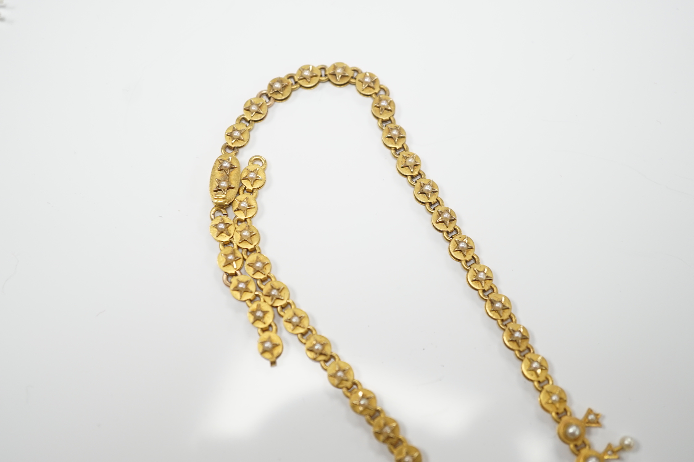 An Edwardian yellow metal and seed pearl set necklace, lacking drops and clasp, 39cm, gross weight 26.2 grams.